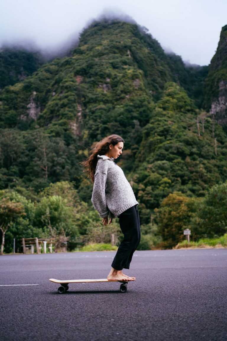 Our team rider Nadine doing a hang ten on the Classic Surfskate. The background is a beautiful green hill in Madeira island