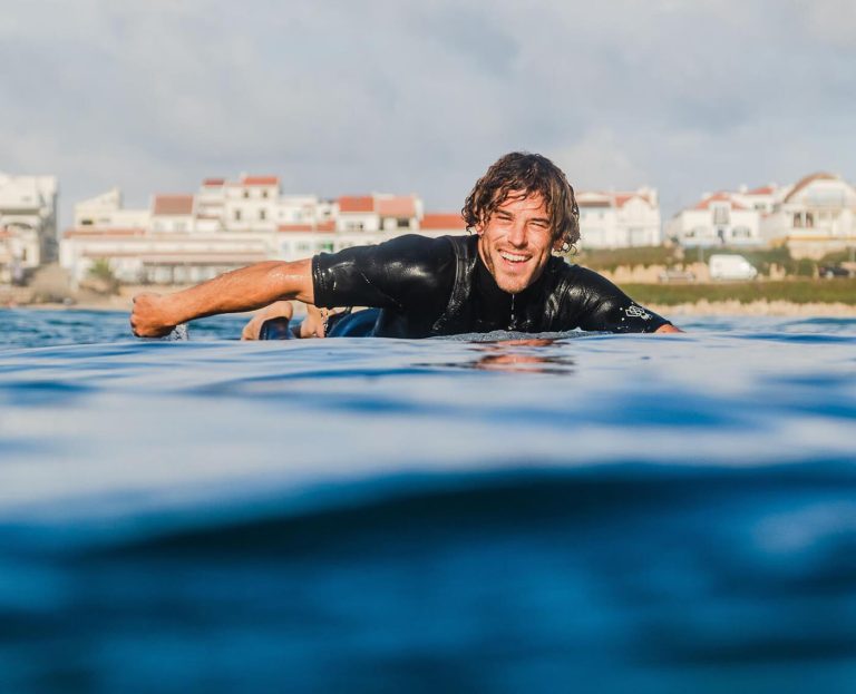 Picture of Craig smiling while paddling in the surf