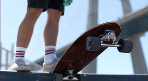 Curfboard Fish Pro Surfskate wooden dream on skatepark under bridge